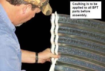applying caulk to the grain bin walls