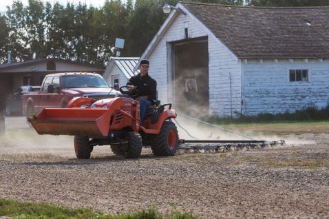 small tractor pulling a garden harrow