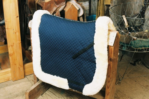 a blue quilted sheepskin saddle pad with a fully lined roll
