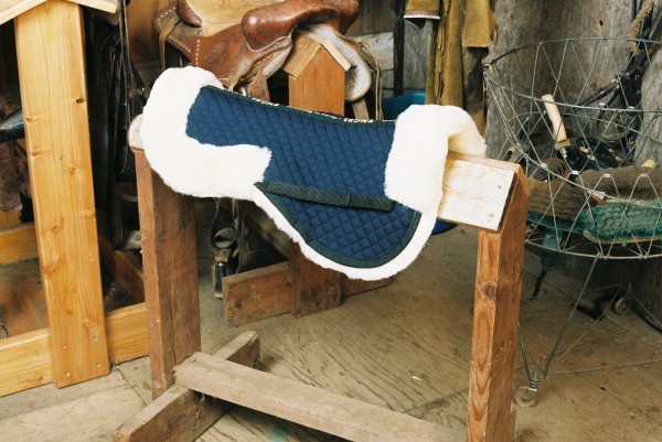 sheepskin half pad with blue quilting and pommel and cantle rolls