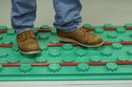 work boots on a crete heat floor insulation panel with pex tubing in place