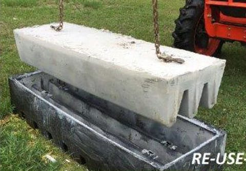 reusable concrete cattle guard form with tractor pulling out a finished guard