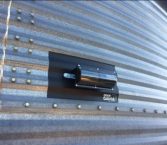 grain gauge mounted to the side of a bulk bin