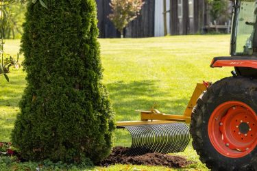 Tractor rake implement near a tree