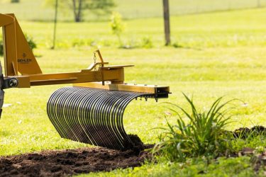 Tractor rake moving backwards during land maintenance